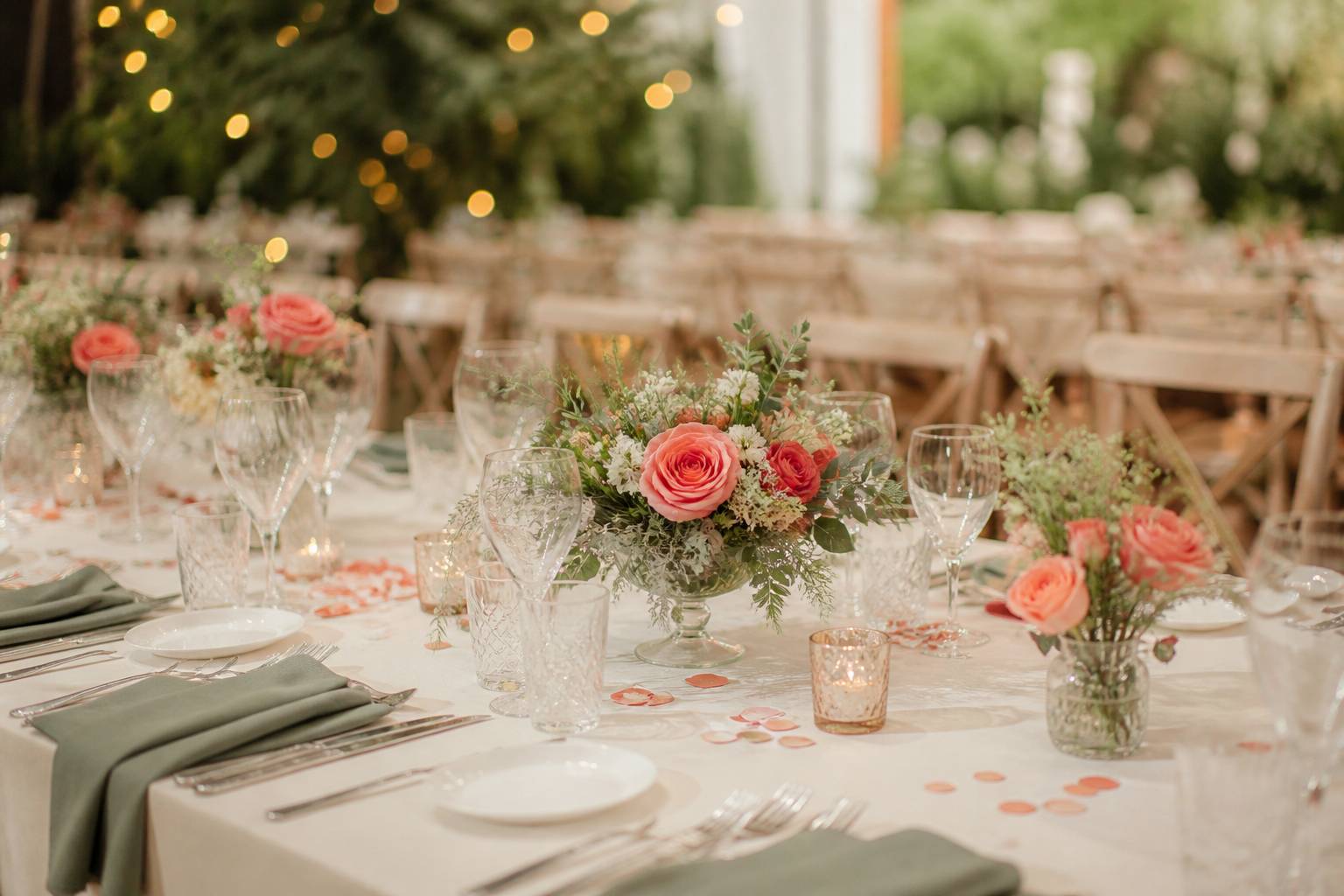 Table de mariage dressée avec couverts, fleurs corail et confetti