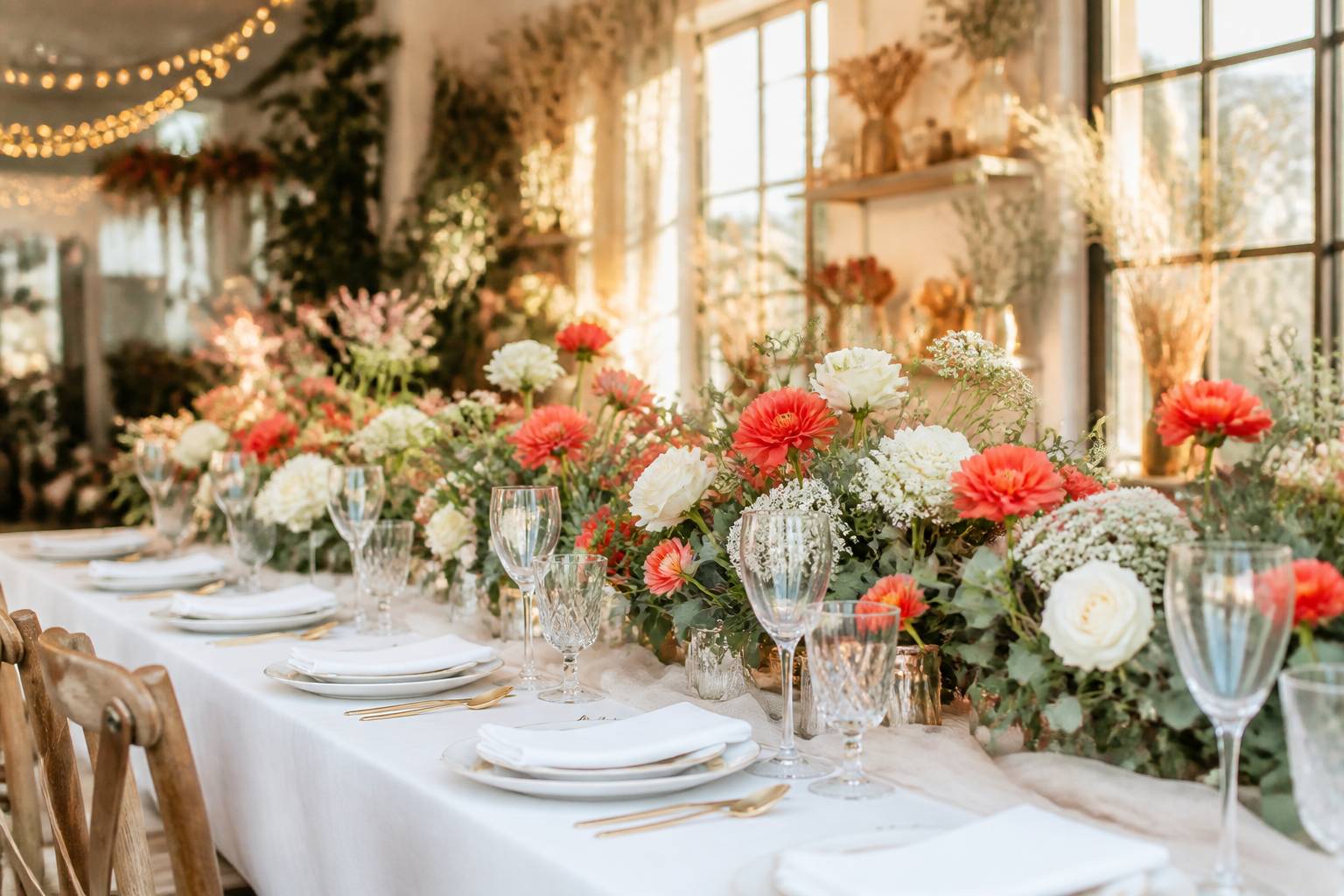 Table de banquet dressée avec centre de table floral crème et corail